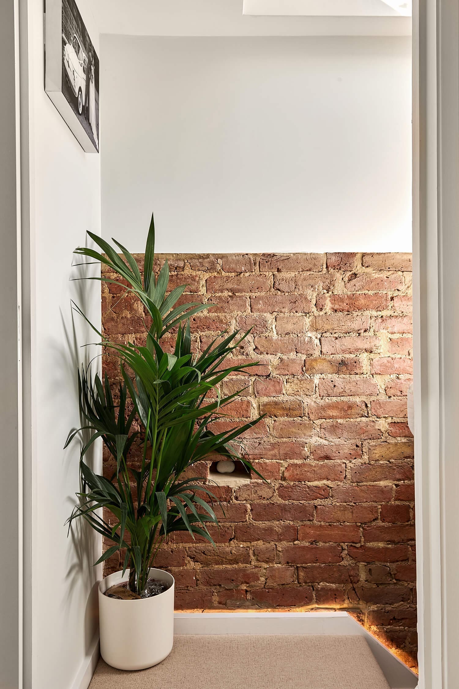 l-shape dormer conversion with exposed brick and led lighting on loft staircase